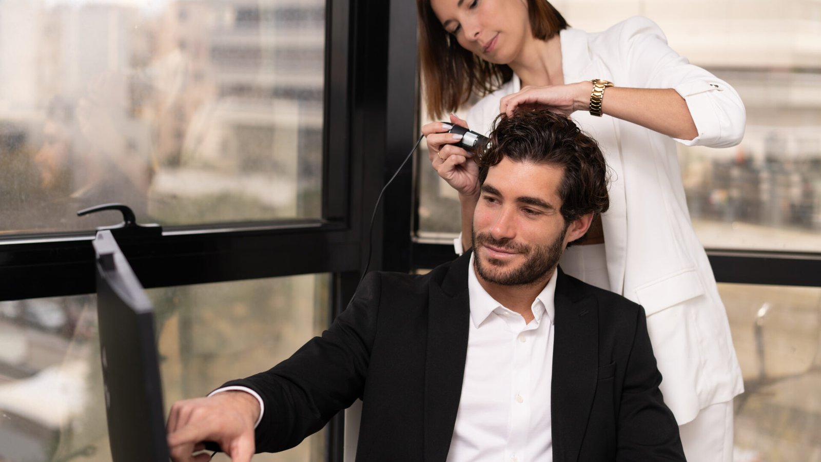 Specialist examining a man’s scalp with magnification during a hair transplant consultation while he looks into a mirror.