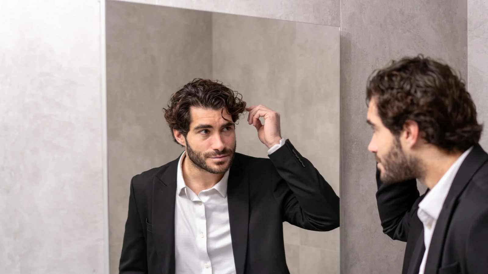 Άνδρας ελέγχει τα μαλλιά του σε εξειδικευμένη ανδρική κλινική μεταμόσχευσης μαλλιών