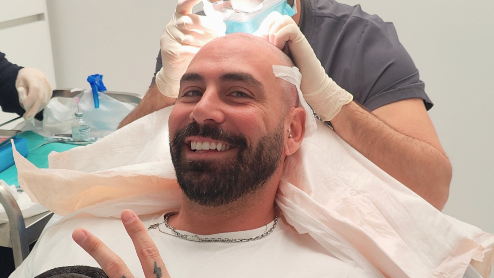 Patient smiling during a hair transplant procedure at the clinic