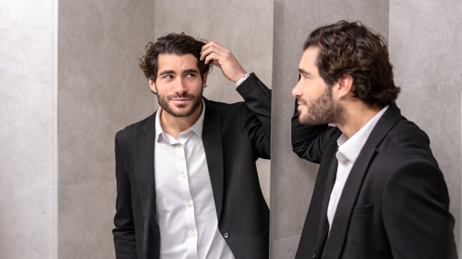 Man looking at his new hair in the mirror after a hair transplant