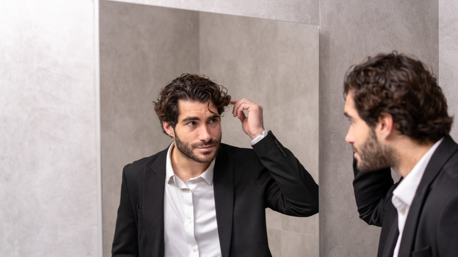 Man checking his hairline and hair density in the mirror